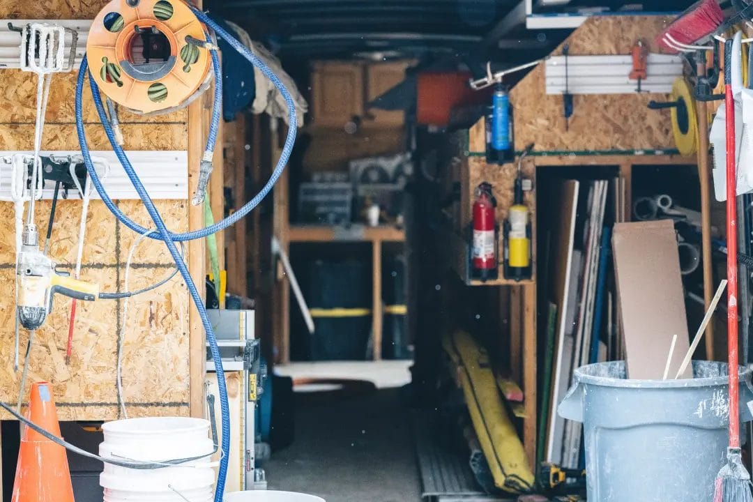 Inside view of a cluttered work trailer with tools and supplies
