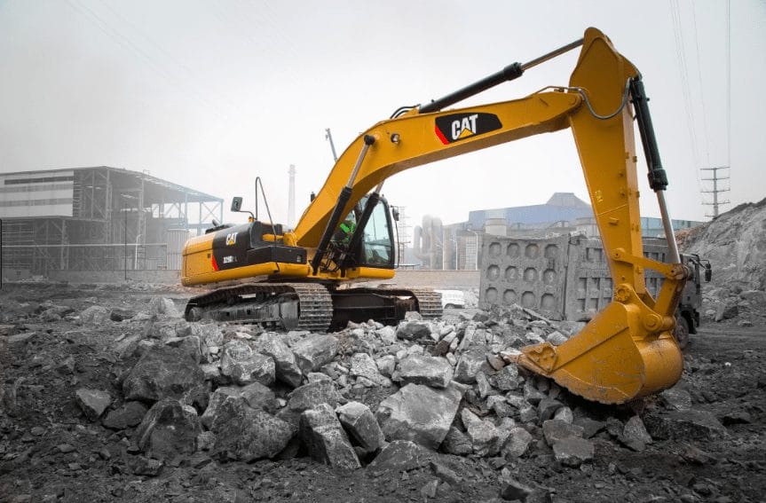 Yellow CAT excavator breaking up rocks on a construction site